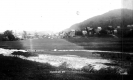 View of Houses Set Behind an Open Field