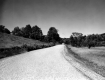 Gravel road through open fields