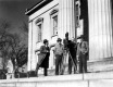 Four men with camera in front of the state house