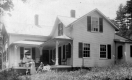 Women and a Dog Outside a Home