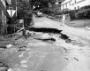 Flood Waters Rushing Through Washed Out Road in Town