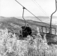 Skiers on a Chair Lift Above Snow Covered Trees
