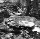 Woman Kneeling On Top of a Large Rock Slab