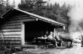 Two men sitting in front of the Little Rock Pond Shelter