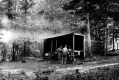 Three men eating in front of the Buffum Shelter