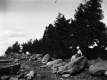Woman in swimsuit on rock in front of boats