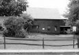 A brick building behind a wooden fence