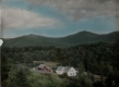 Barn and Houses Enclosed by Green Mountains