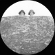 Two Women Peering over a Rock Face