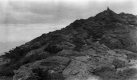 View of Man Sitting Atop Mountain Peak