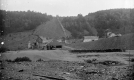 Wooden-framed buildings in front of a hill