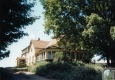 Dirt Driveway and a Wooden House