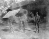 Boy with Horse in Front of a Barn