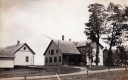Two dwellings on dirt road.