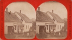 Woman, men and children in front of a white house