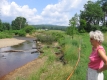A Woman Relaxes by the Little River