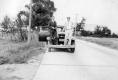Two men standing on the front of an automobile