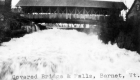 Water flowing under covered bridge