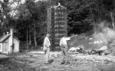 Two Men by a Wooden Tower