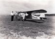 Four men in front of a plane