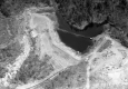 A body of water surrounded by cleared land and trees