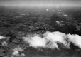 Aerial photograph of a forested hill and towns