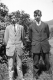 Two Men in Front of a bush