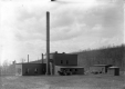 Horse drawn carriage in front of a factory 