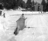 Ice Cutting near a wooden-frame building