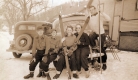 Group of Skiers Next to Automobiles
