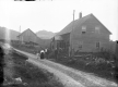 Family on dirt road in front of home