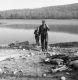 Two men along the shore of a lake