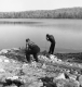 Two men along the shore of a lake