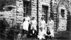 Individuals Posed in Front of Home