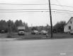 Automobiles in a field next to a home