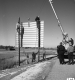 Eight Men Two on Ladders Secure Sign Interstate 89