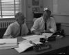 A.M. Kight and Hal Howard Sitting at a Desk
