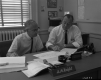 A.M. Kight and Hal Howard Sitting at a Desk