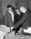 Three Men Look at Small Machine