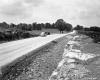 Automobile and Tractor at Road with Outcrop