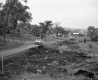 Automobiles on Dirt Road Next to Area of Loose Soil