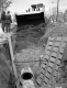 Two Men and Tractor at Drainage Construction Site