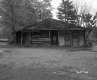 Dilapidated One-Story House with Trees and Parked Car