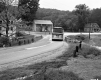 Bus on Paved Road in Residential Area with Four Buildings