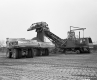 Two Trucks and Crane at Construction Site