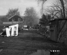 Unpaved Driveway with Two Story Home and Junk Yard