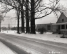 House with Porch on Road with Industrial Building