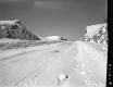 Snowy Highway with Rocky Outcrops Leading Uphill