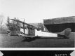 Antique Car and Plane Parked in Front of Garage
