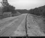 State Aid Road 1 in Wells, Looking Easterly from Side of Road, River and Wood framed Building